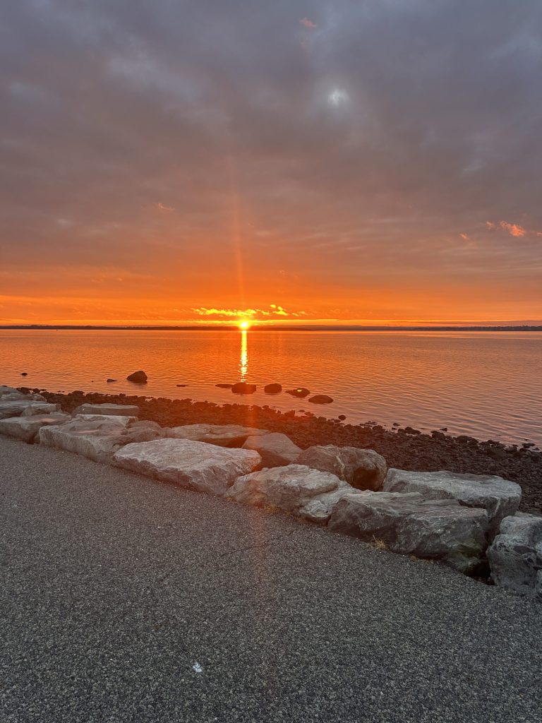 Bright orange sun setting over the water. 